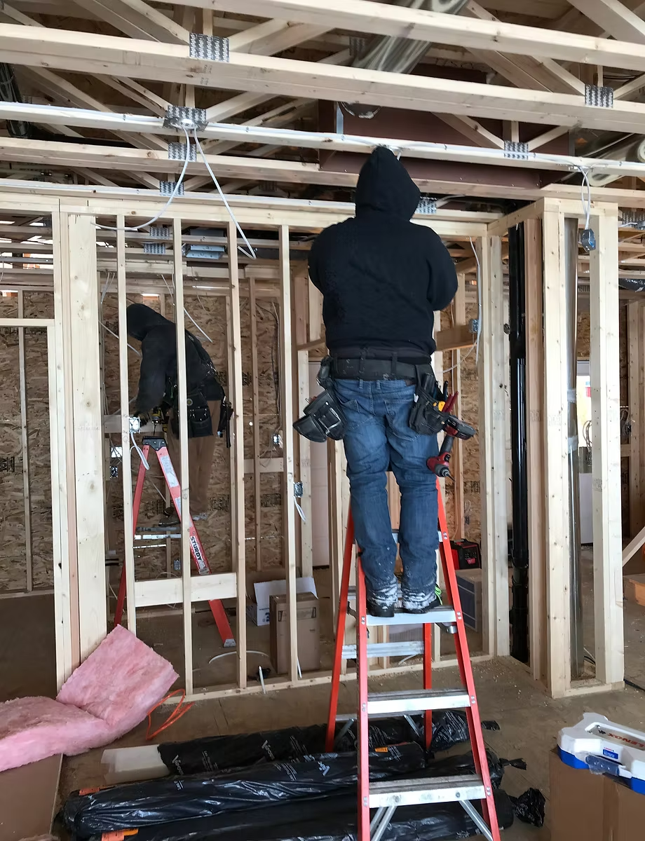 Donahue Electric crew framing-stage wiring on a new residential build